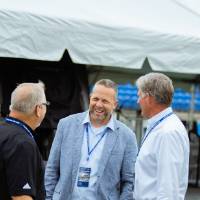 Guests standing on the field, talking at the Jamie Hosford Football Center dedication.